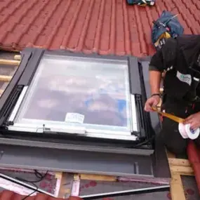 Handwerker montiert Dachfenster auf Ziegeldach, Dachfenster Einbau Renovierung Haus.