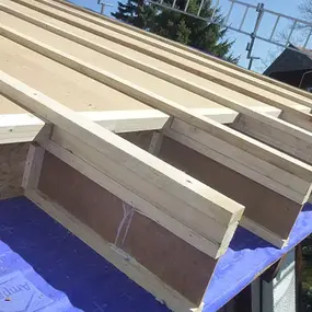 Holzdachkonstruktion mit sichtbarer Unterspannbahn und Sparren beim Hausbau.